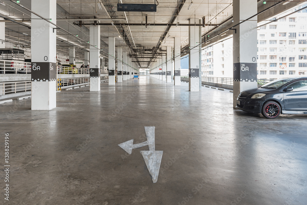 interior of parking garage with car and vacant parking lot