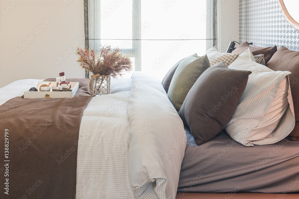 glass vase of plant with wooden tray on luxury bed in luxury bedroom