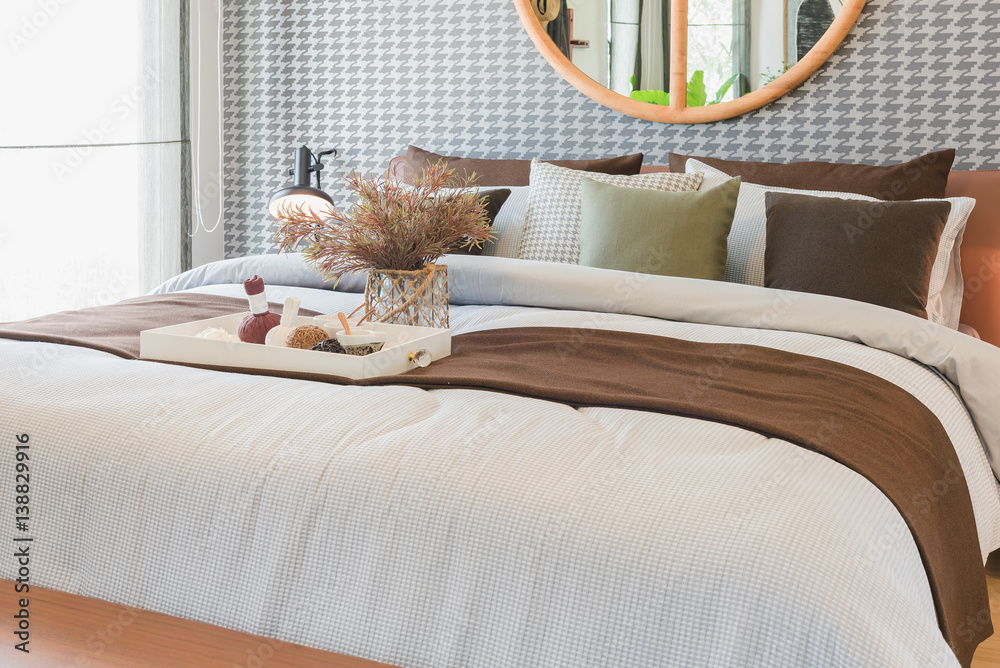 glass vase of plant with wooden tray on luxury bed in luxury bedroom