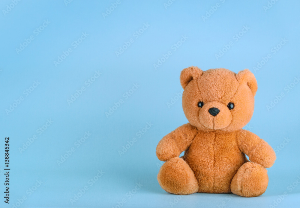 Toy teddy bear on blue background with copy space