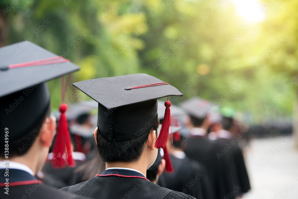 Back of graduates during commencement at university. Close up at graduate cap