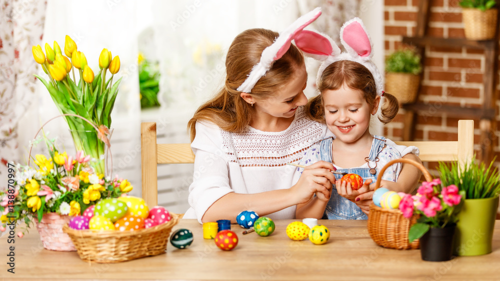 Happy easter! family mother and child daughter paint eggs for holiday Easter