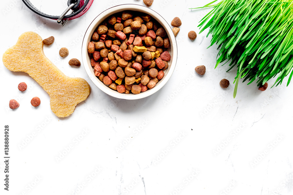 dry dog food in bowl on stone background top view