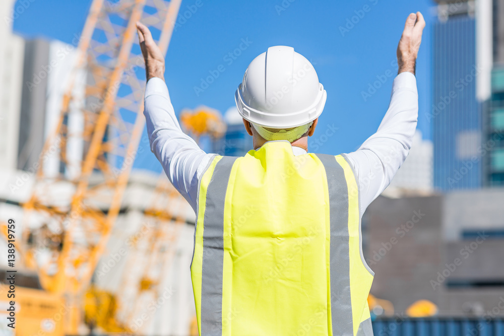 Senior foreman in glasses doing his job at building area on sunny day