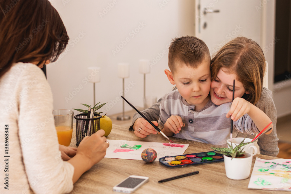 Brother and sister painting at home