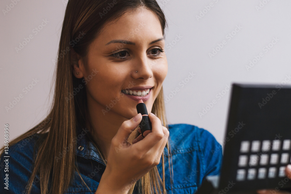 Pretty young girl putting make up