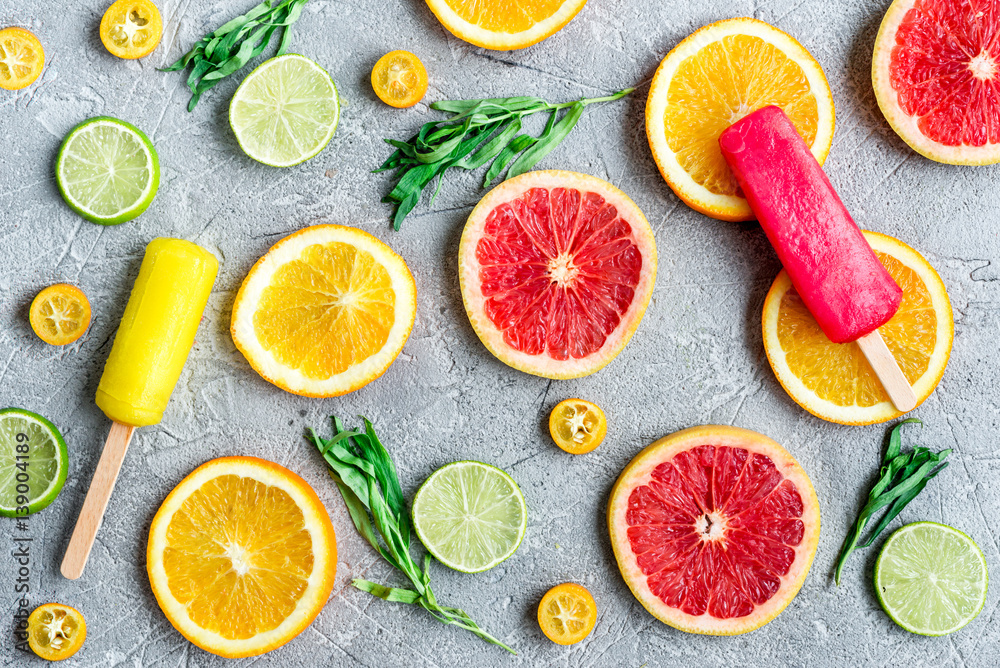 citrus popsicles with fruit slices on stone background top view pattern