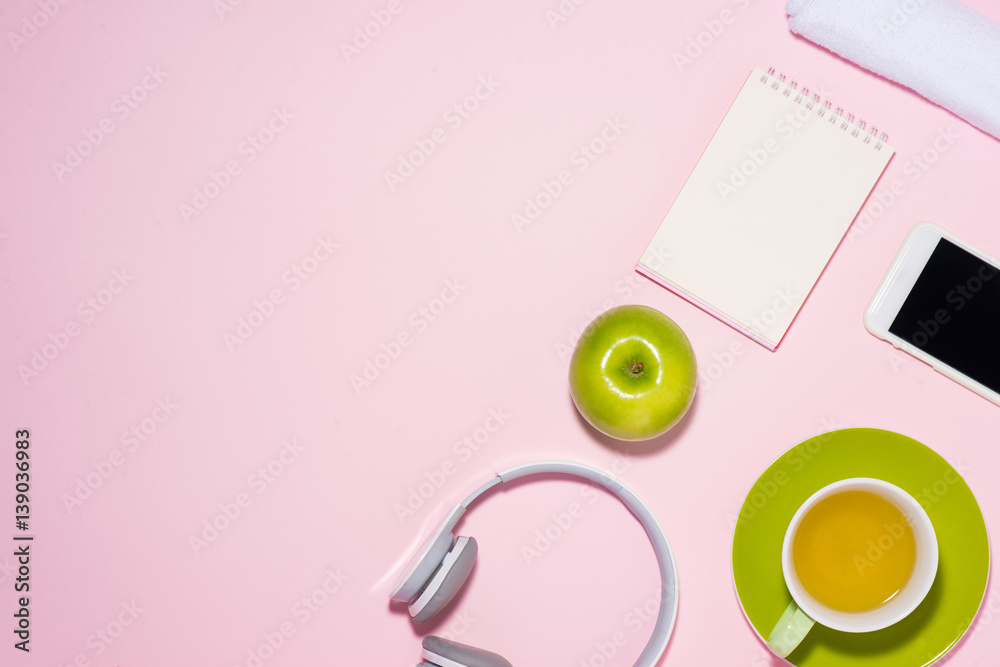 Healthy lifestyle concept. Sneakers, tea, apple and headphone on pastel color background.