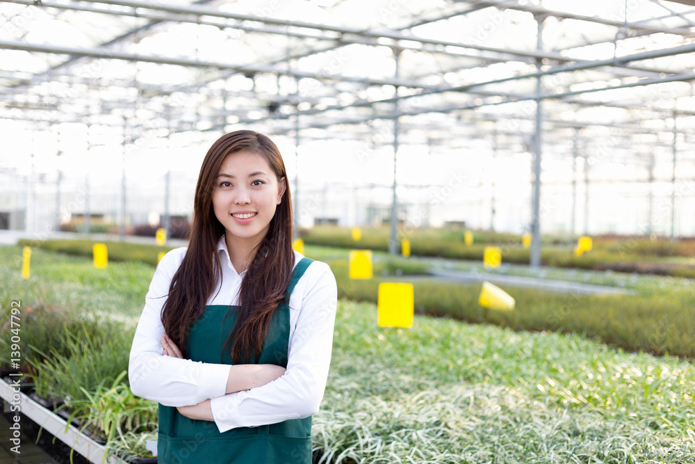 young asian woman works in green house