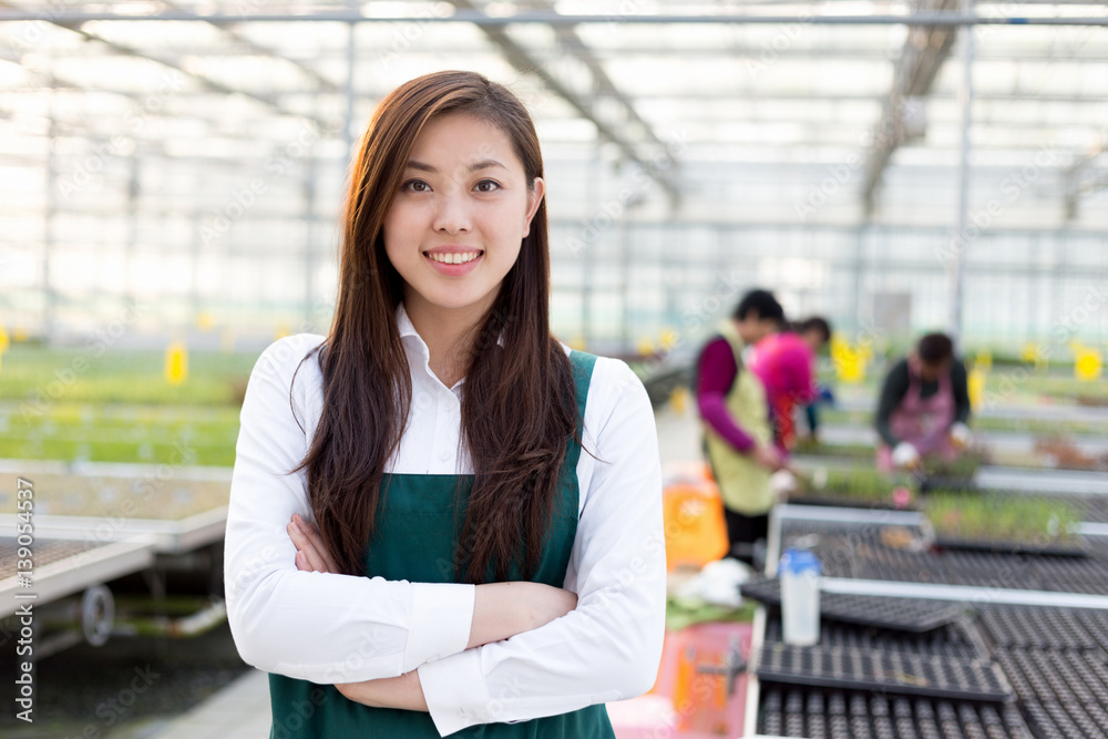 young asian woman works in green house