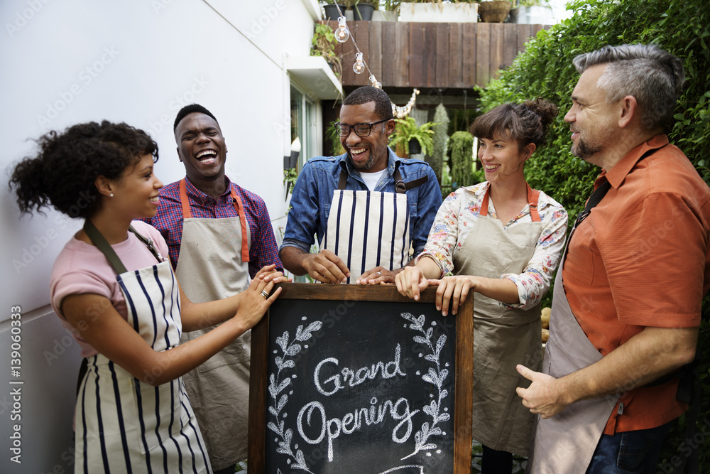 Group of friends with grand opening board together