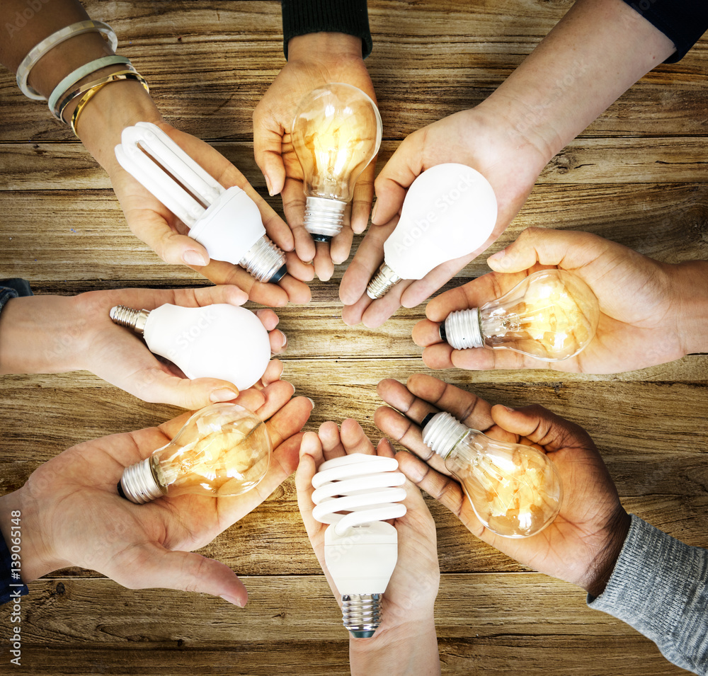 Group of hands holding creativity ideas light bulb sharing in aerial view