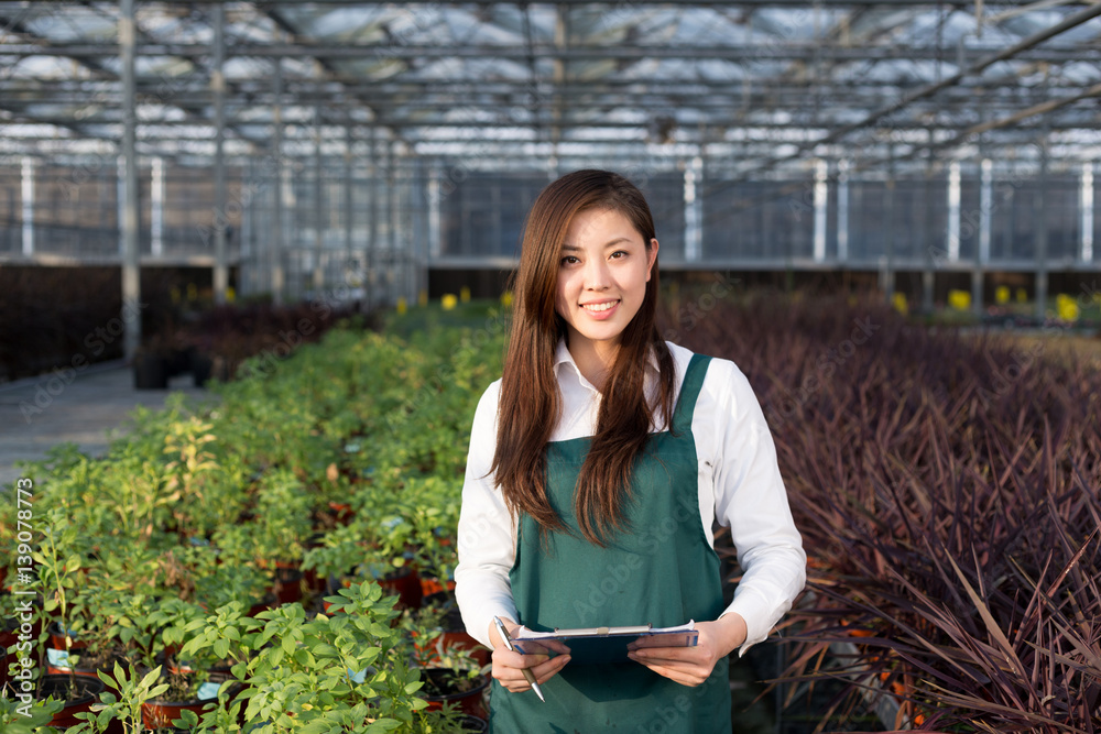 young asian woman works in green house