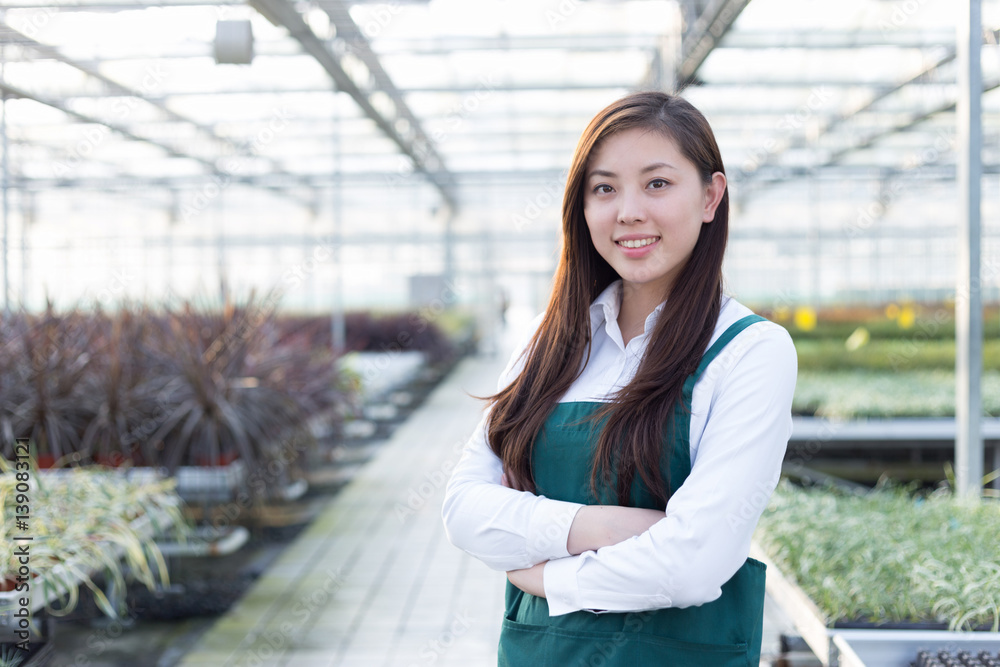 young asian woman works in green house