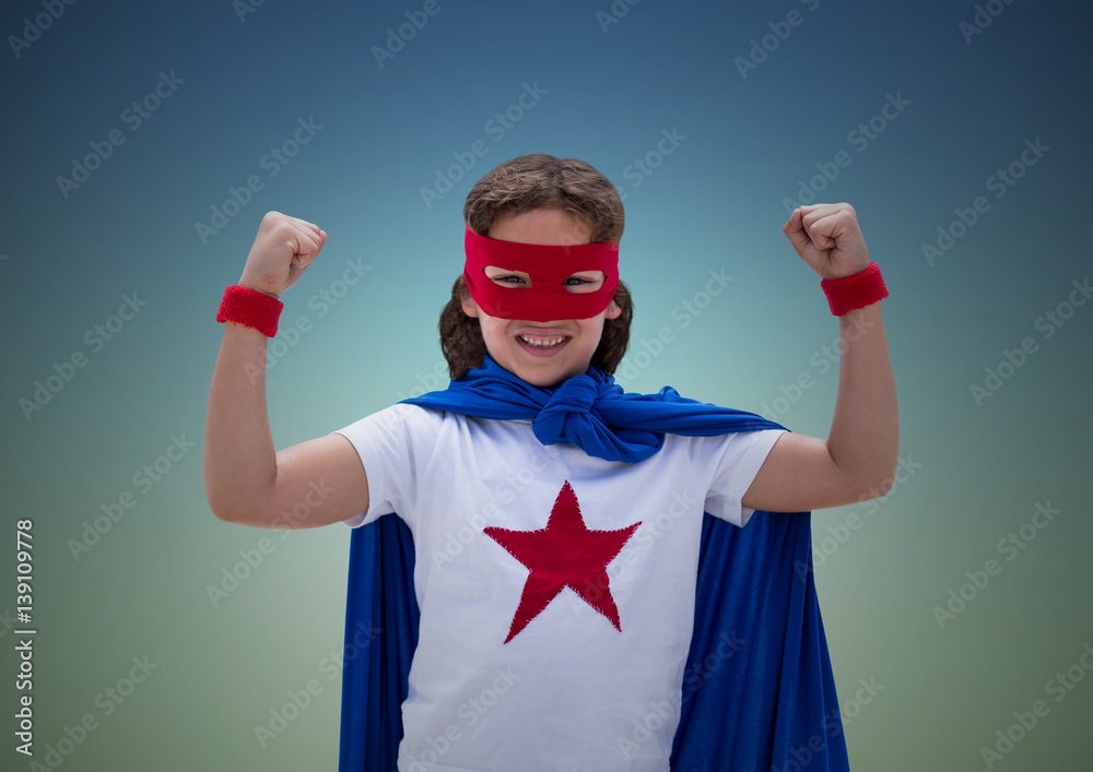 Boy in superhero costume showing fists against blue background