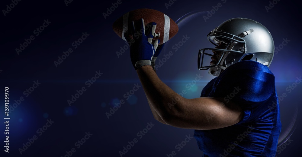 American football player catching a ball against blue background