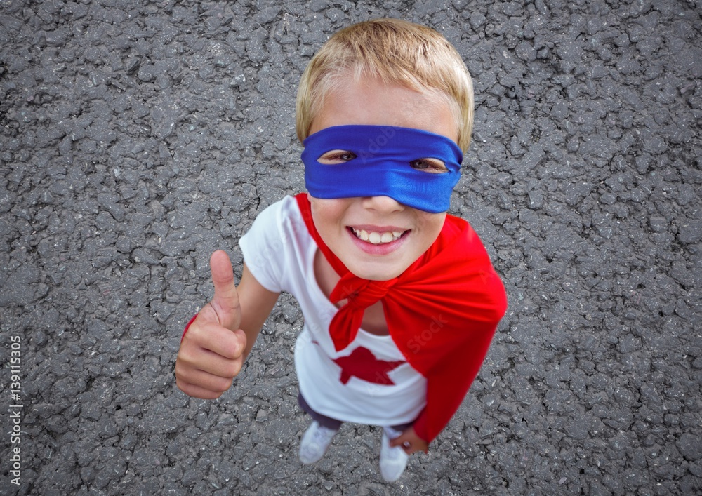 Boy in superhero costume showing thumbs up