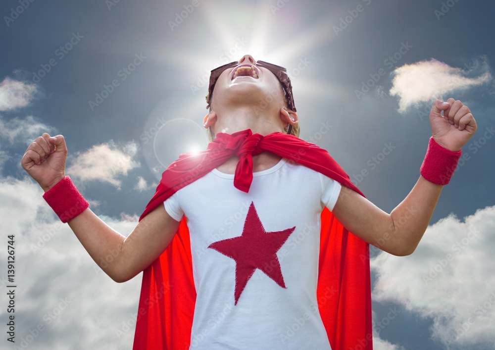 Kid in superhero costume screaming against sky in background