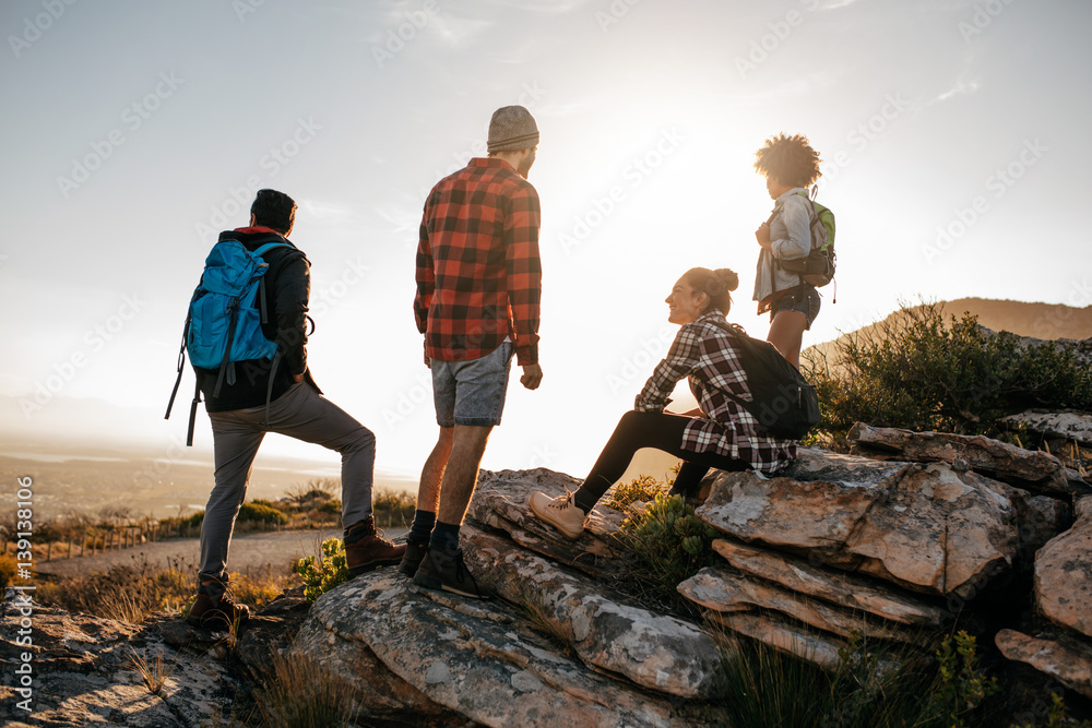 Group of hikers on top of hill and enjoying view