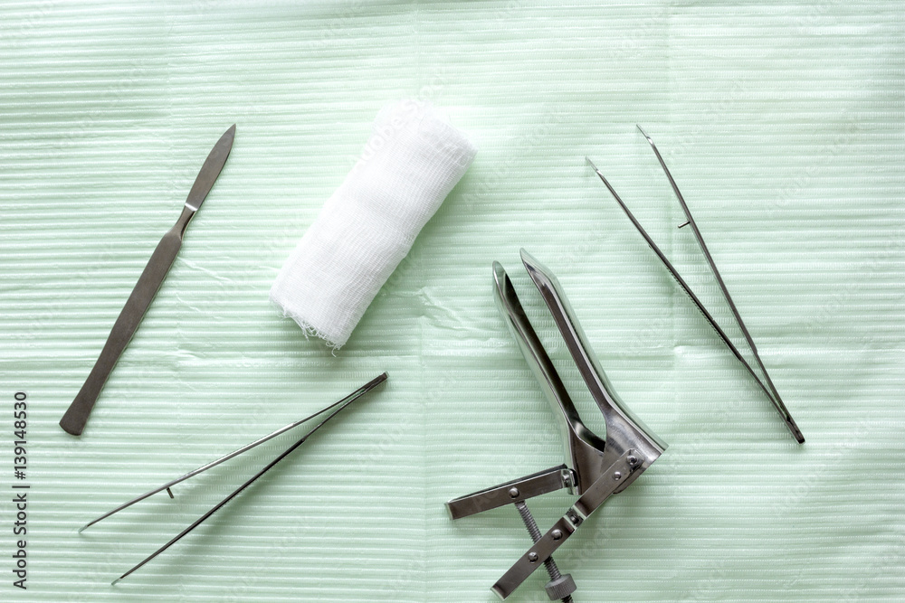 instruments of gynecologist on green background top view