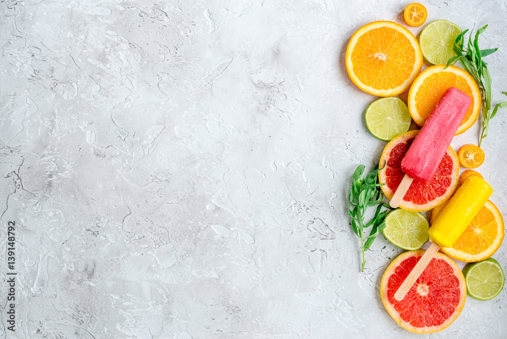 citrus popsicles with fruit slices on stone background top view mockup