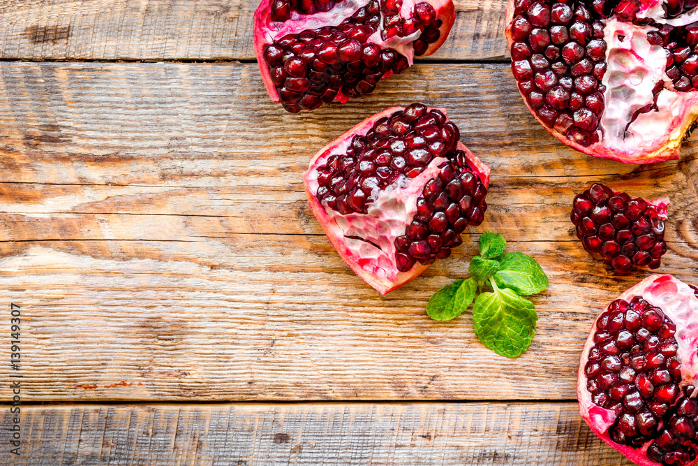 sliced pomegranate on wooden background top view