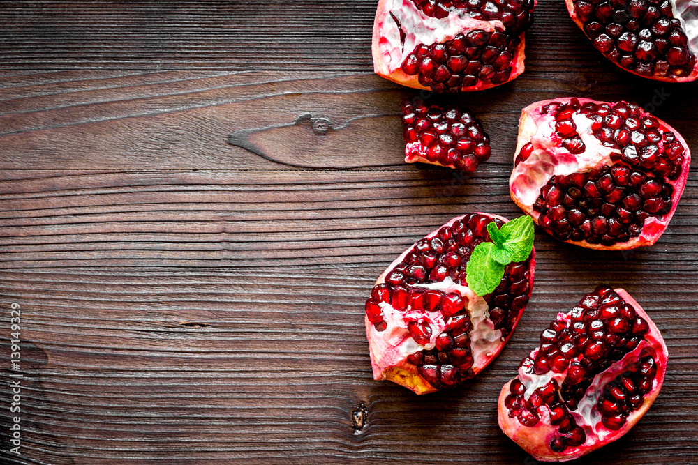 sliced pomegranate on wooden background top view