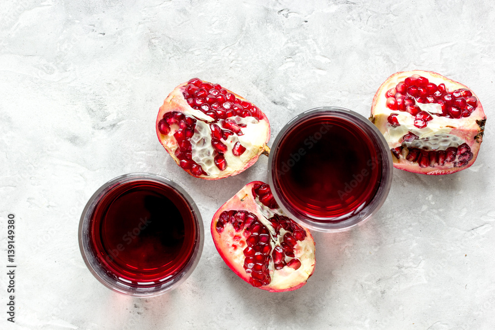 glass of pomegranate juice with fresh slices on stone background top view