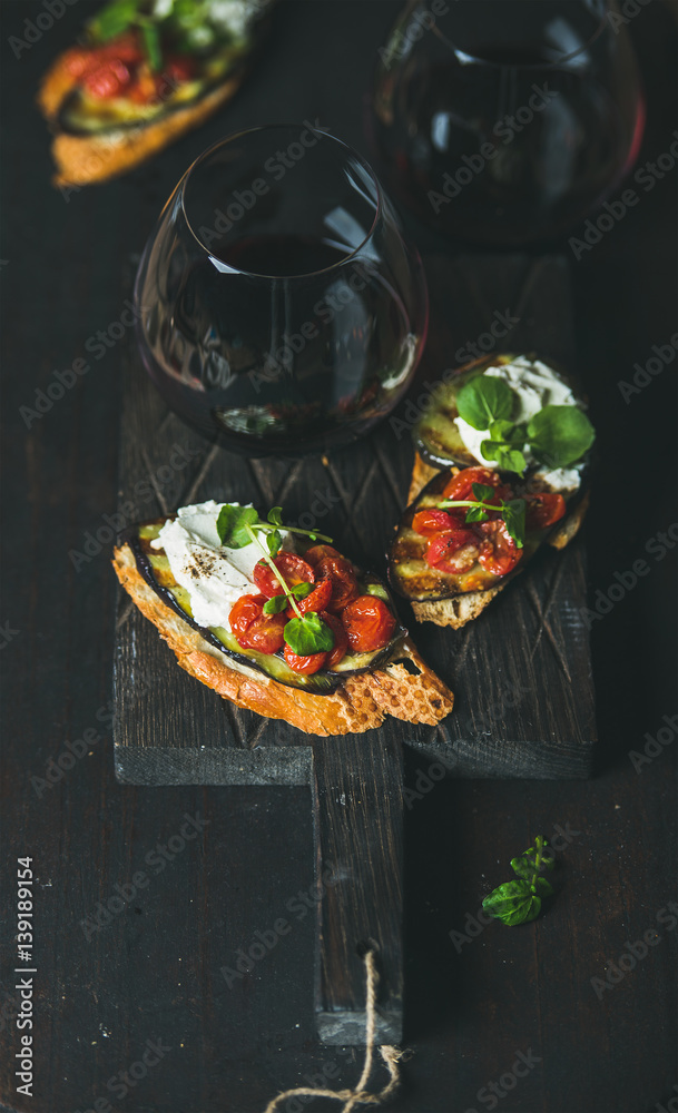 Wine and snack set. Brushetta with roasted eggplant, cherry tomatoes, garlic, cream cheese, arugula 