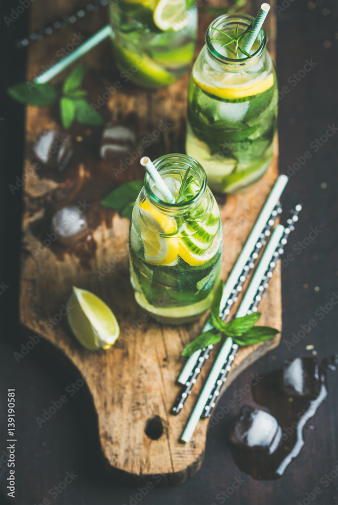 Citrus fruit and herbs infused sassi water for detox, healthy eating, dieting in glass bottles on wo