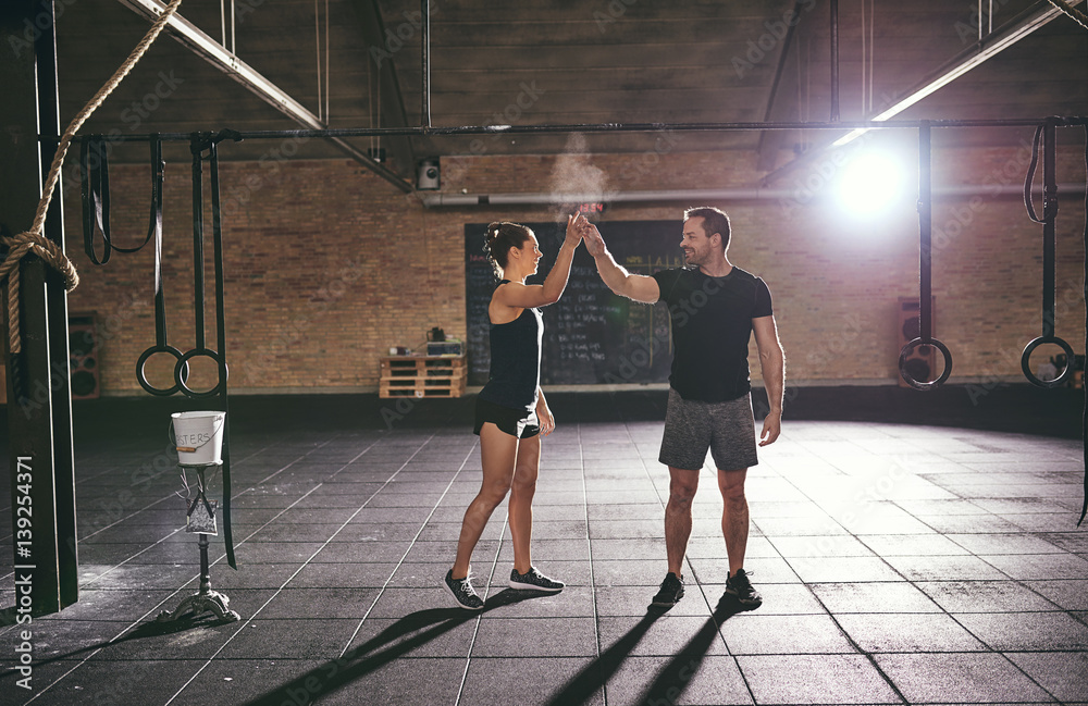 Two young athletic adults exchanging high five