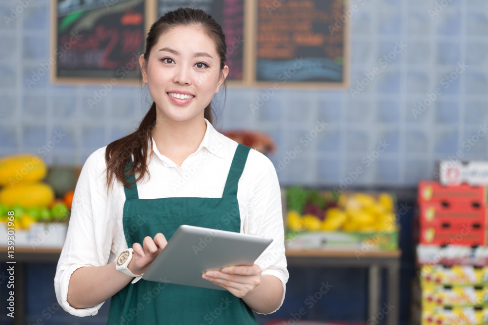 年轻漂亮女人在水果店工作