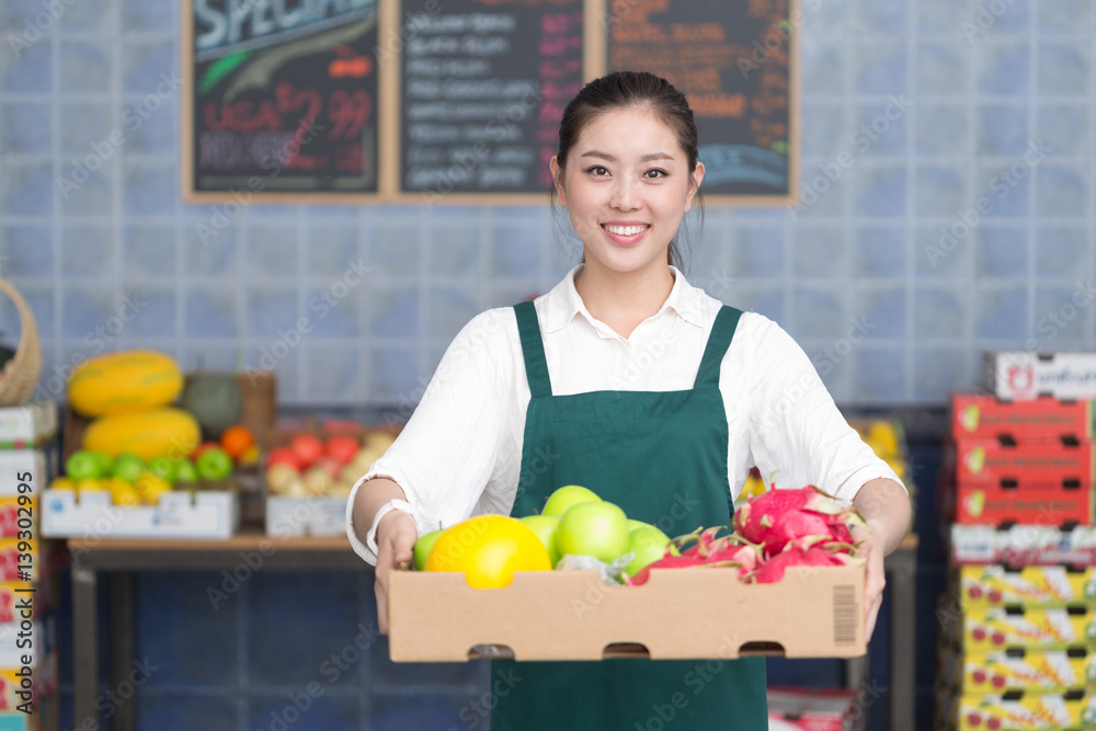 年轻漂亮女人在水果店工作