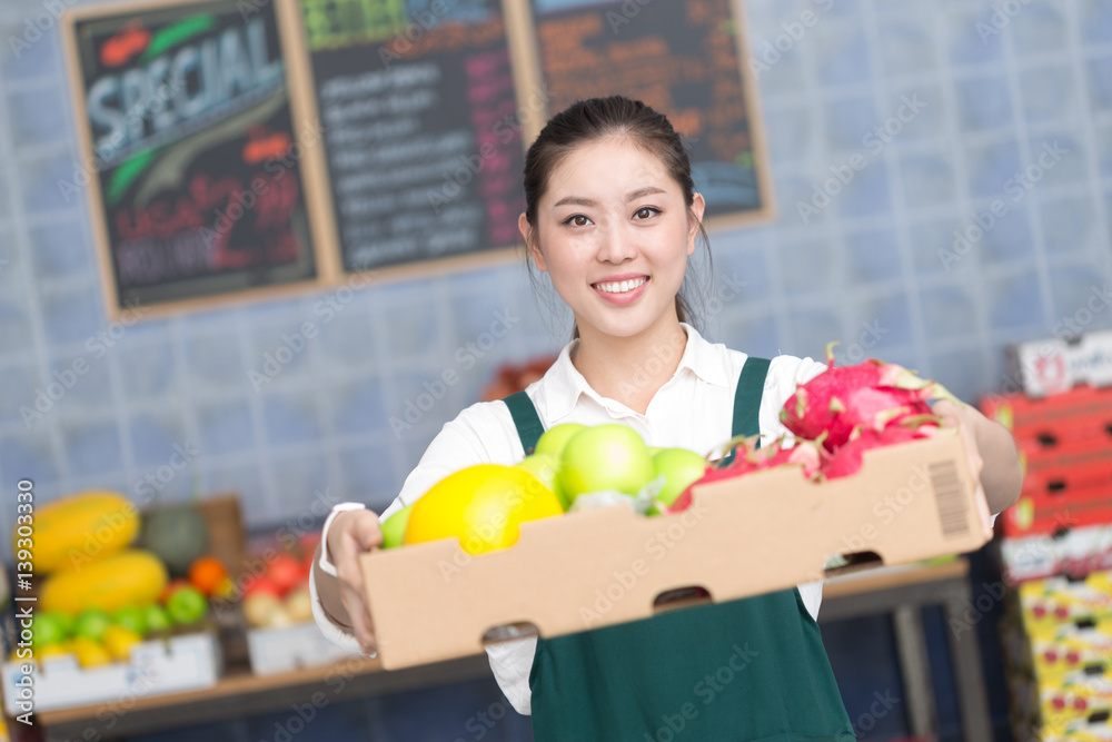 young pretty woman works in fruit store