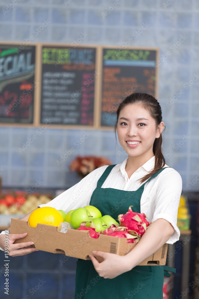 年轻漂亮女人在水果店工作