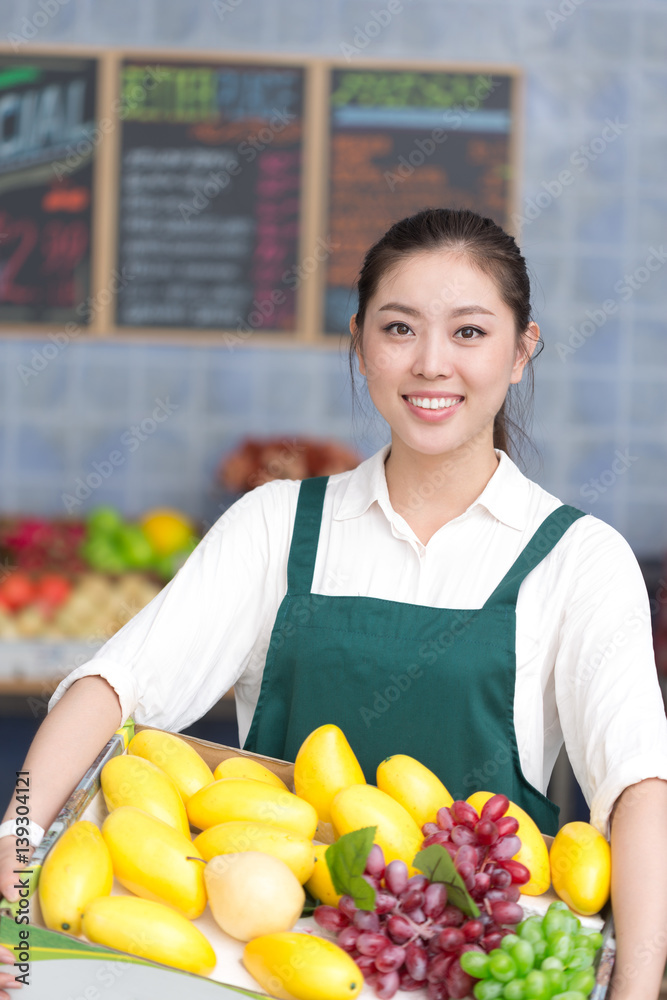 young pretty woman works in fruit store