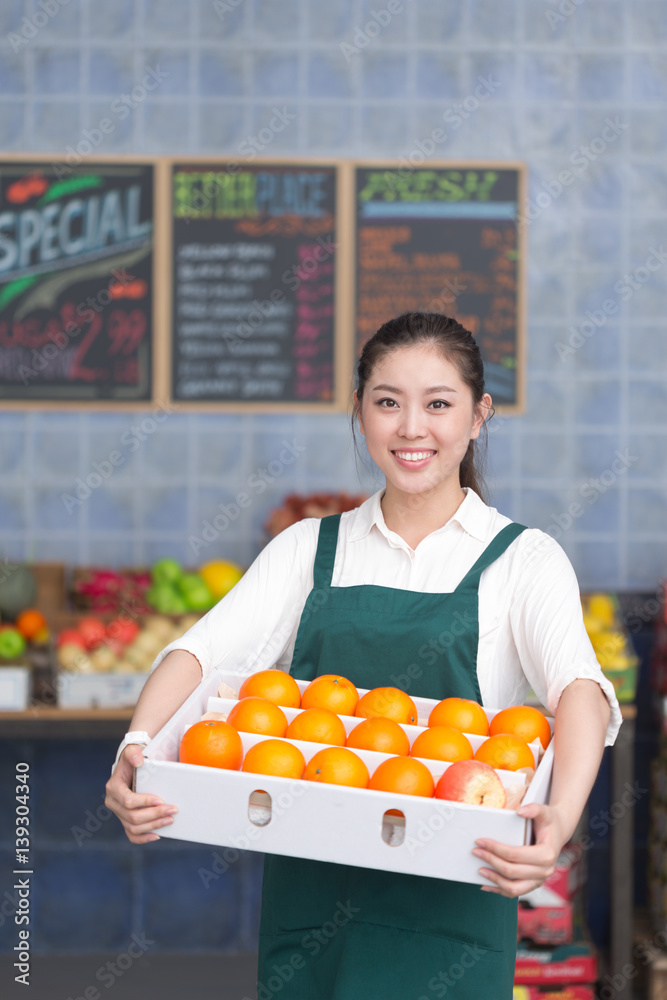 young pretty woman works in fruit store