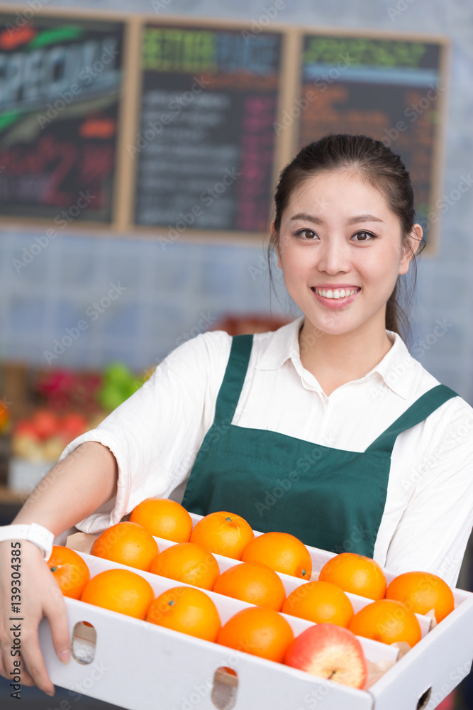 年轻漂亮女人在水果店工作