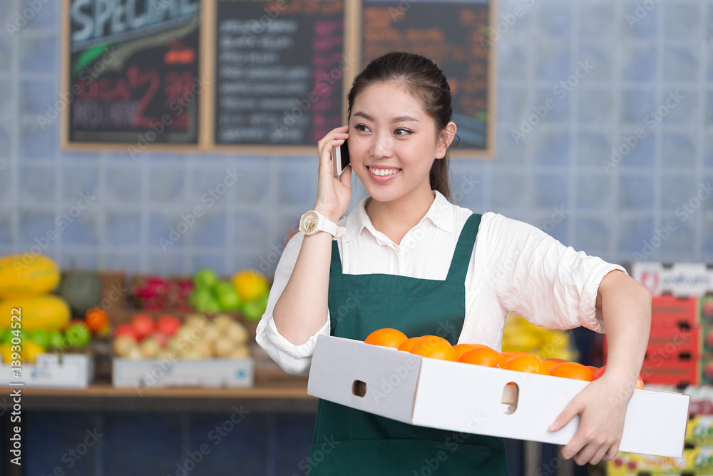 young pretty woman works in fruit store