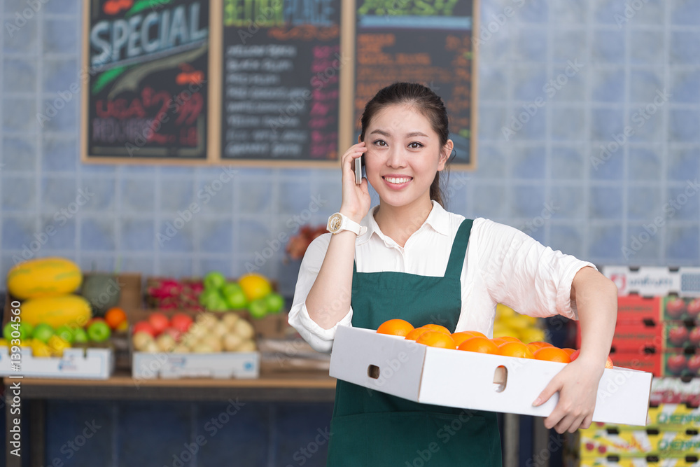 young pretty woman works in fruit store