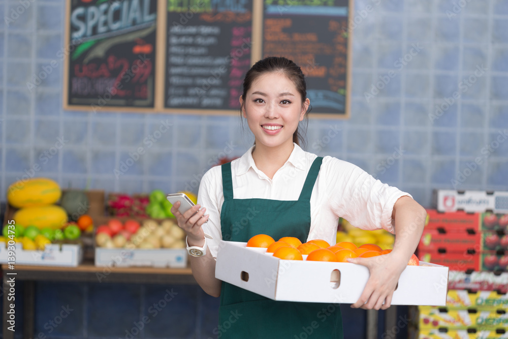 年轻漂亮女人在水果店工作