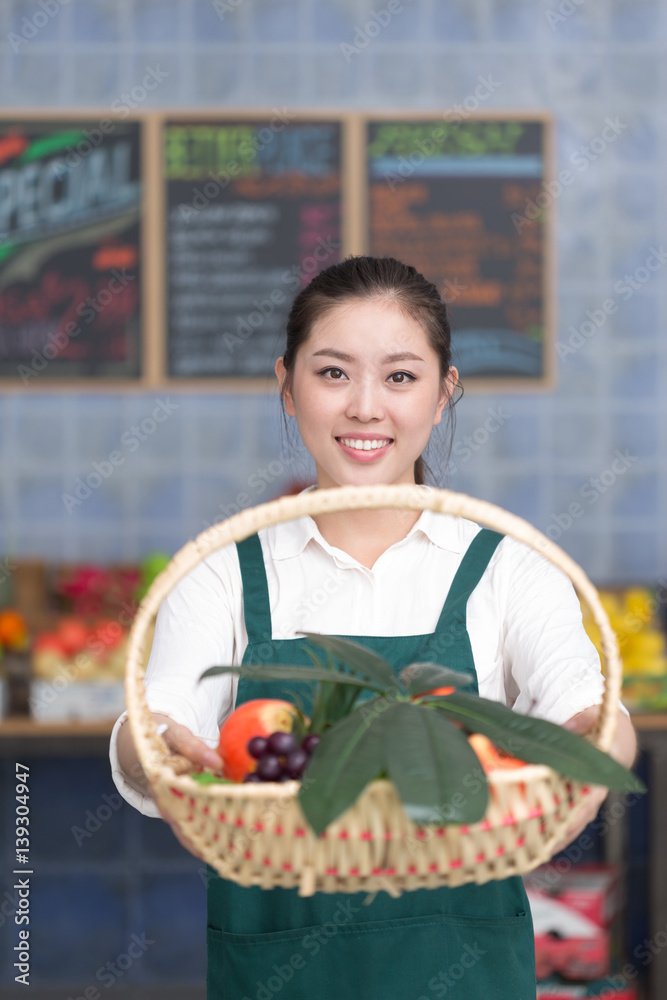 young pretty woman works in fruit store