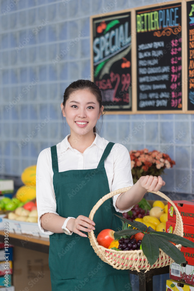 young pretty woman works in fruit store