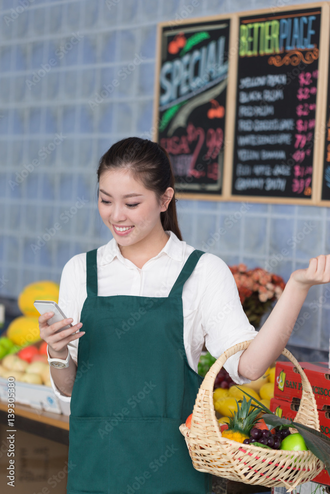 young pretty woman works in fruit store