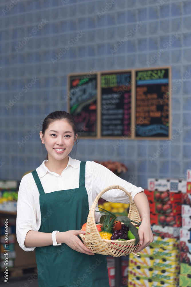 young pretty woman works in fruit store