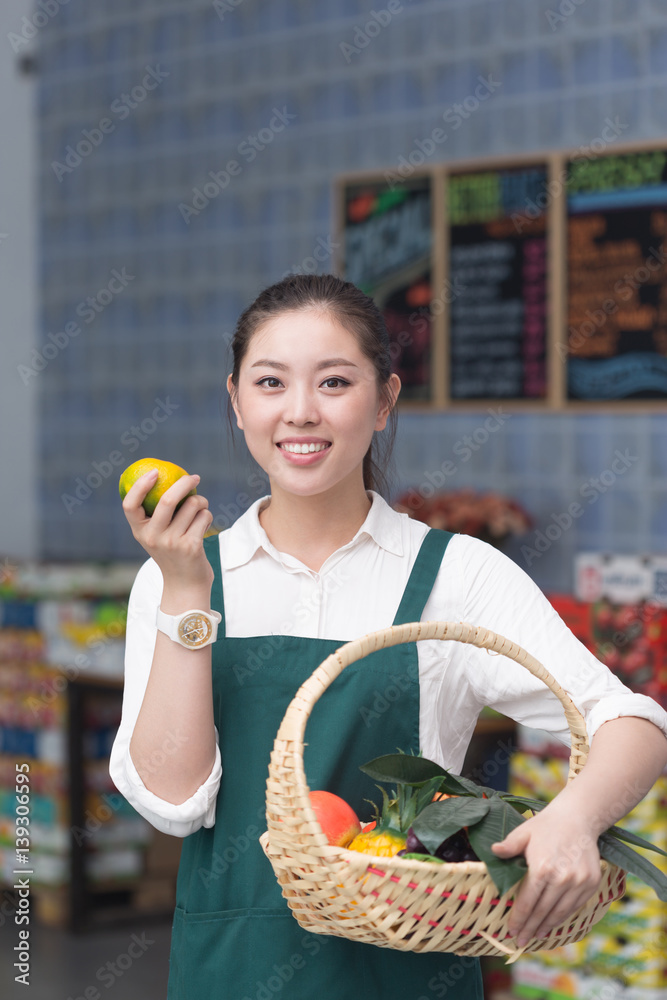 young pretty woman works in fruit store