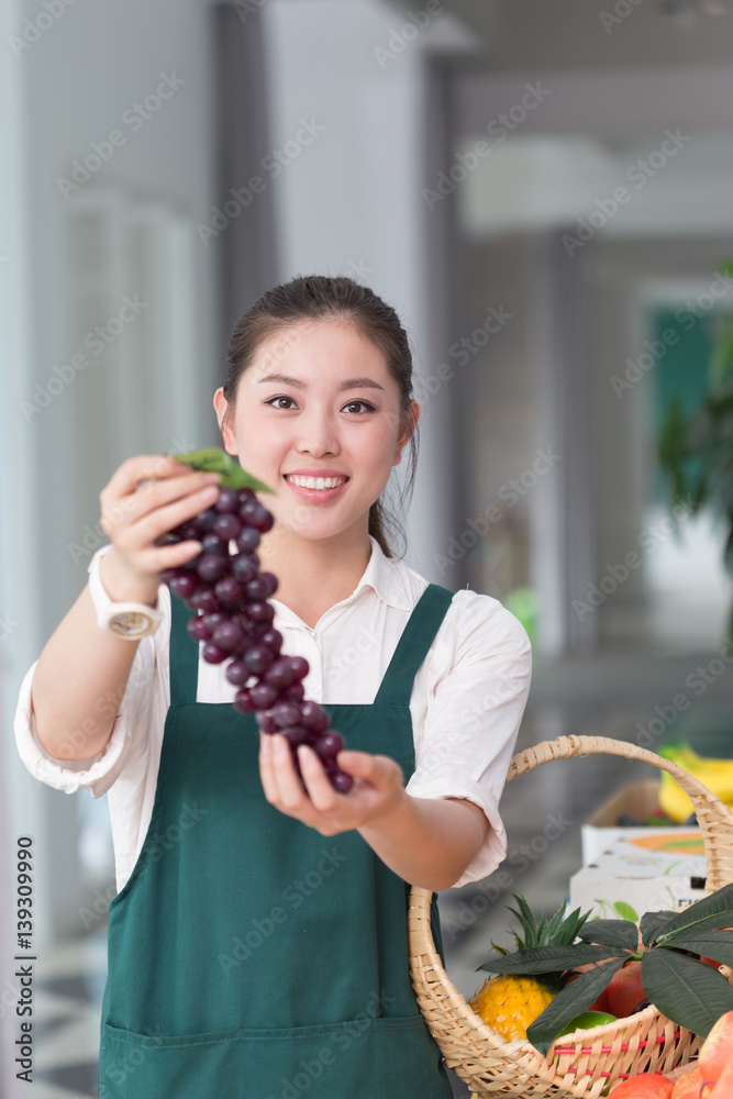 young pretty woman works in fruit store