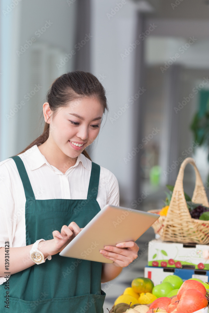 young pretty woman works in fruit store