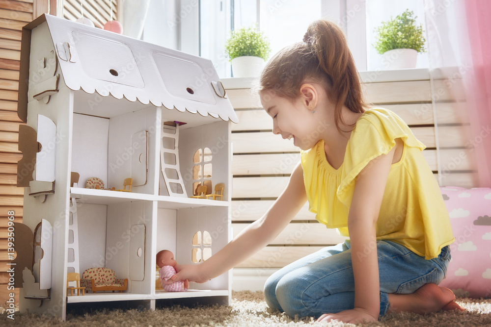 girl plays with doll house