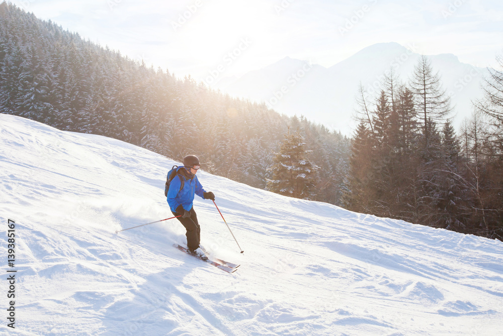 skier in sunset mountains, downhill skiing